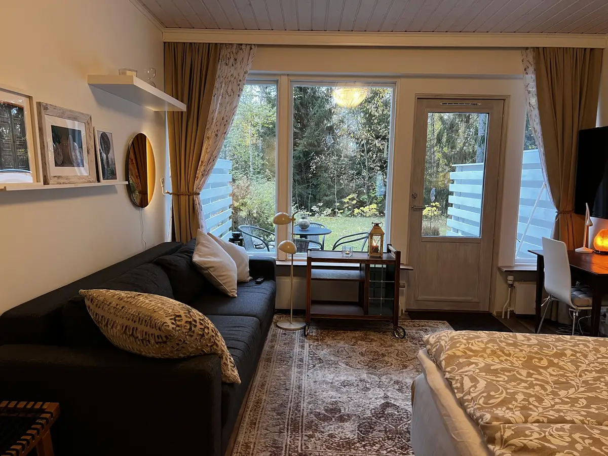 Living room and sleeping space with view into back garden